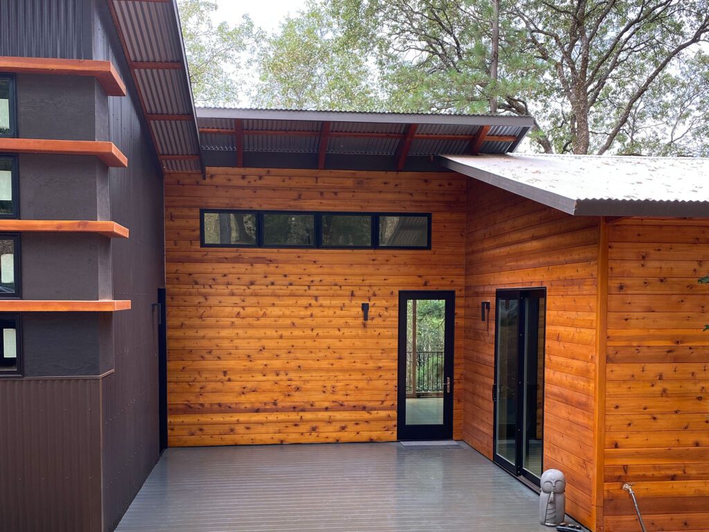 A wooden house with a black door and windows.